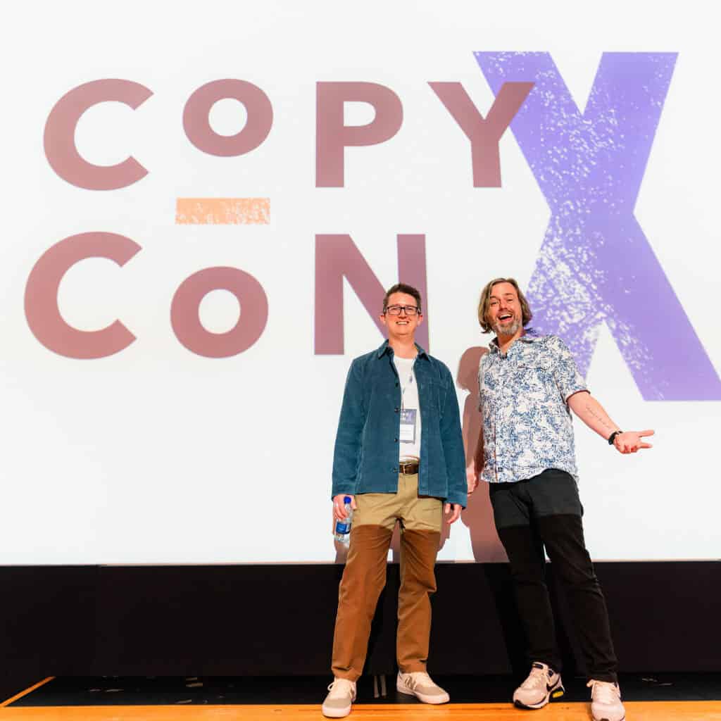 David McGuire, posing onstage at CopyCon X with event organiser Leif Kendall of ProCopywriters.